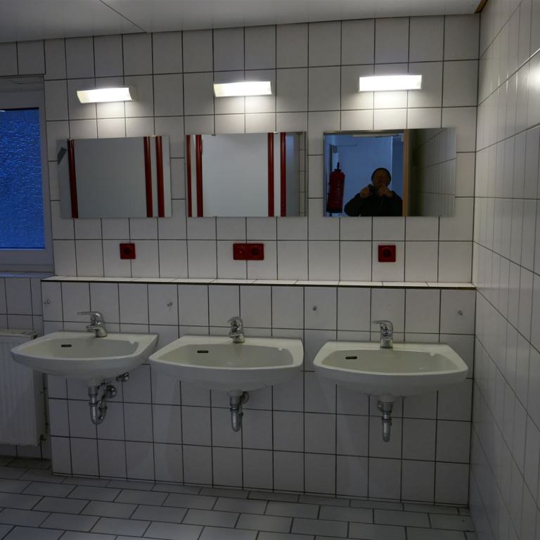 Dusch und Waschraum im Keller mit 3 Waschbecken und 4 Duschkabinen 01